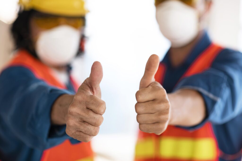 Dois colegas de equipe usando EPI e fazendo jóia